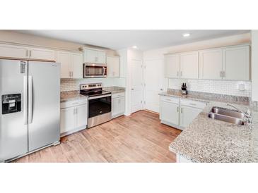 Well-lit kitchen features stainless steel appliances, granite countertops, and subway tile backsplash at 7205 Finnigan Rd, Charlotte, NC 28215