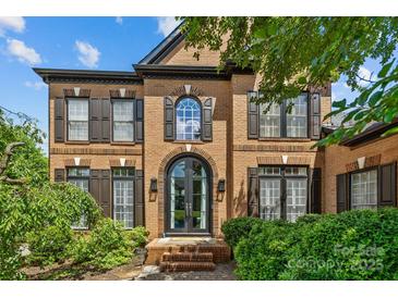 Brick two-story home with black trim, arched windows, and manicured landscaping at 9625 Donna Ve Ln, Charlotte, NC 28277
