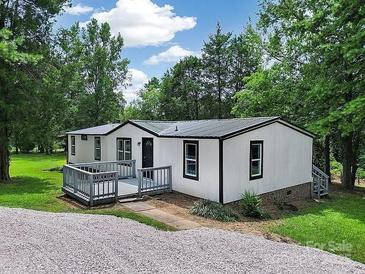 Charming single-story home with a cozy front deck and a gravel driveway at 10379 Turnplow Dr, Davidson, NC 28036