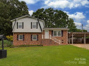 Charming two-story brick home with a well-maintained lawn and attached carport, perfect for suburban living at 1040 Spring Dr, Gastonia, NC 28052