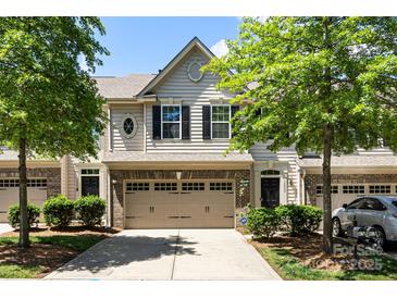 Charming townhouse with a two-car garage, brick accents, and manicured landscaping at 12009 Elizabeth Madison Ct, Charlotte, NC 28277