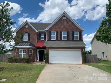 Charming two-story brick home featuring a two-car garage, manicured lawn, and a classic design at 2018 Rockycreek Ln, Monroe, NC 28112