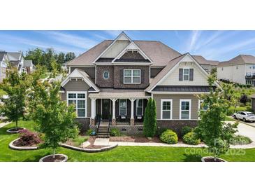 Beautiful two-story home with brick and siding, lush landscaping, and inviting front porch at 220 Forsythia Ln, Tega Cay, SC 29708