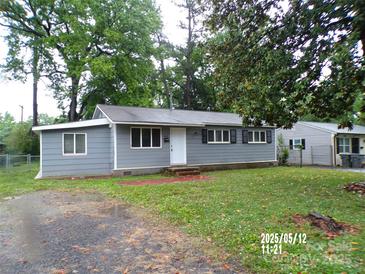 Charming single-story home with gray siding, black shutters, and a well-maintained front yard and mature trees at 2409 Thornton Rd, Charlotte, NC 28208