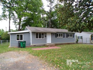 Charming single-story home with gray siding, a well-manicured lawn, and an inviting entrance at 2409 Thornton Rd, Charlotte, NC 28208
