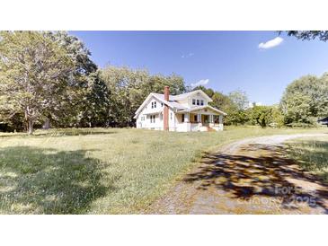 Two-story home with a brick chimney and a inviting front porch nestled on a lot with mature trees at 2645 Kool Park Ne Rd, Hickory, NC 28601