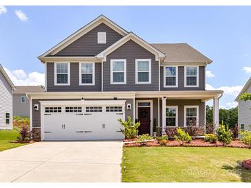 Charming two-story home boasts a well-manicured lawn, a two car garage, and beautiful landscaping at 3023 Ballester Rd, Fort Mill, SC 29707