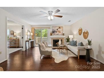 Bright living room with hardwood floors, fireplace, and a sliding glass door to a balcony at 5011 Sharon Rd # Q, Charlotte, NC 28210