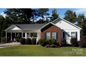 Inviting single-story home with a well-manicured lawn and convenient covered parking at 625 Wildwood Dr, Rock Hill, SC 29730