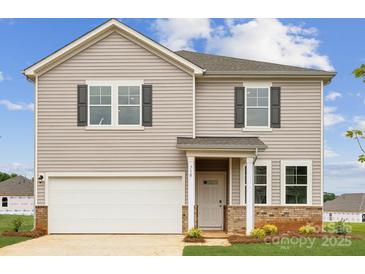 Two-story home showcasing gray siding, black shutters, a two-car garage, and a covered entryway at 710 Olde England Dr, Lincolnton, NC 28092