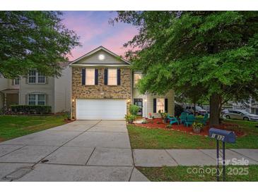 Charming two-story home with a well-maintained lawn, inviting front porch area, and two car garage at 1332 Waterlily Ln, Charlotte, NC 28262
