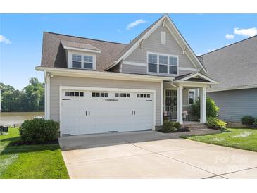 Charming two-story home with a two-car garage, well-manicured lawn, and lake view at 136 Preston Rd, Mooresville, NC 28117