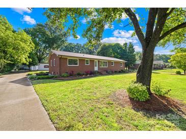 Charming brick home with lush landscaping and a well-manicured lawn, creating a welcoming curb appeal at 1408 Delview Rd, Cherryville, NC 28021