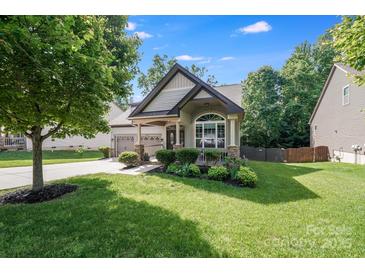 Charming home with lush lawn, tasteful landscaping, and welcoming covered porch, perfect for relaxing at 14512 Brotherly Ln, Charlotte, NC 28278