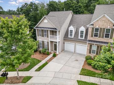 Inviting two-story townhome boasting a two-car garage, second-story porch, and mature landscaping at 14822 Rocky Top Dr, Huntersville, NC 28078