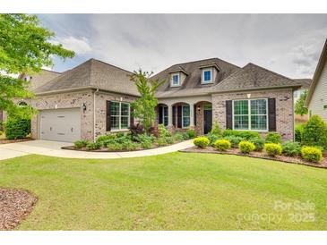 Beautiful brick home featuring a lush front yard with mature landscaping and an attached two-car garage at 15927 Vale Ridge Dr, Charlotte, NC 28278