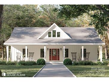 Charming home featuring board and batten siding, a welcoming front porch, and inviting rocking chairs at 1821 Country Club Rd, Wadesboro, NC 28170