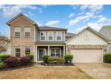 Charming two-story home featuring a brick and siding exterior, landscaped front yard, and attached two-car garage at 2014 Drawbridge Dr, Fort Mill, SC 29707