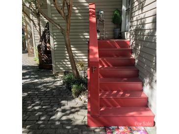 Inviting front entrance features vibrant red steps, charming decor, and lush landscaping, creating a warm and welcoming ambiance at 415 W 7Th St # F, Charlotte, NC 28202