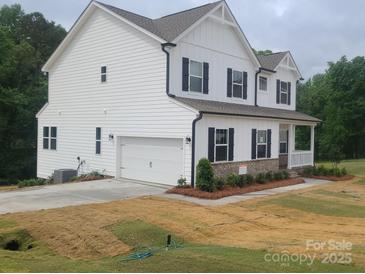 Charming two-story home with white siding, black shutters, attached garage, and a cozy front porch at 5630 Galloway Dr # 49, Stanfield, NC 28163