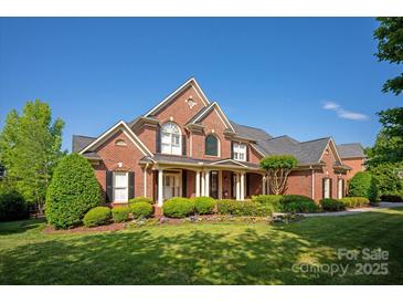 Stunning brick home with manicured landscaping and a well-maintained lawn on a clear day at 7507 Meadowgate Ln, Waxhaw, NC 28173