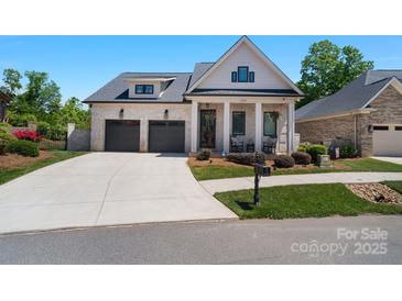 Charming brick home featuring a two-car garage, inviting front porch and landscaped front yard at 1428 Spring Ridge Ln, Denver, NC 28037