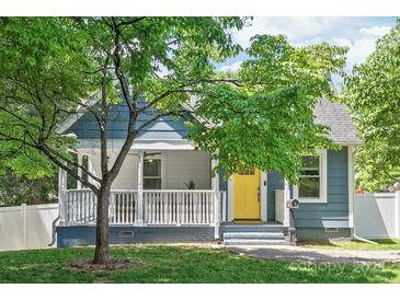 Charming blue home featuring a bright yellow front door, porch, and well-maintained lawn at 219 Lee St, Fort Mill, SC 29715