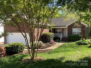 Charming brick home with a well-manicured lawn, flowerbeds, and a two-car garage at 2339 Wednesbury Ct, Kannapolis, NC 28083