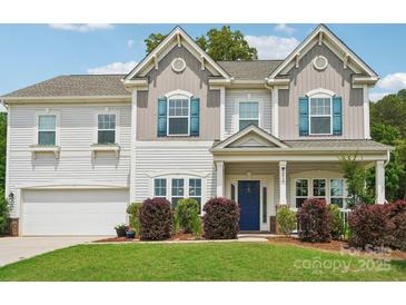 Well-maintained two-story home with a manicured lawn, blue shutters, and a welcoming front porch at 3218 Gilroy Dr, Fort Mill, SC 29707