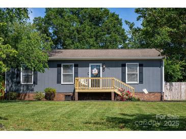 Charming single-story home showcasing a welcoming front porch, fresh exterior paint, and lush green lawn at 386 Greenlea Cir, Taylorsville, NC 28681