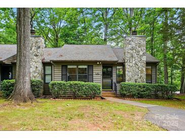 Charming home featuring stone chimneys, neutral siding, trimmed hedges, and a mature tree shading the front yard at 392 Tall Oaks Trl, Fort Mill, SC 29715