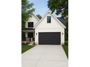 Charming two-story home with a black garage door, light grey driveway, and a well-manicured lawn at 418 Harrison St, Statesville, NC 28677