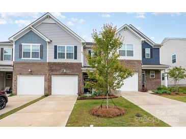 Charming townhome featuring mixed siding, brick accents, and a one car garage at 6011 Chelsea Oaks Rdg, Tega Cay, SC 29708