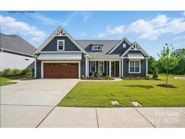 Charming single-Gathering home featuring a well-manicured lawn, a two-car garage, and welcoming front porch at 605 Brennan St # 31, Mount Pleasant, NC 28124