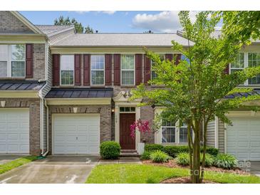 Charming brick townhouse features a one-car garage, manicured lawn, and a classic front door at 108 N Arcadian Way, Mooresville, NC 28117