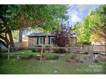Charming brick home featuring a cozy front yard with mature trees and quaint rustic accents at 1111 Green Street Ext, Rock Hill, SC 29730