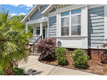 Charming home entrance with landscaped walkway, featuring gray siding and classic architectural details at 1201 Pegram St, Charlotte, NC 28205