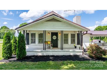 Charming front porch with a 'Welcome' sign and lovely decorative plants and shrubs at 1300 Nc 90 W Hwy, Taylorsville, NC 28681