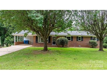Charming brick home featuring a covered carport, mature trees and lush landscaping at 1753 28Th Ne St, Hickory, NC 28601