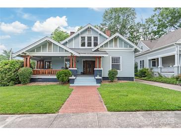 Charming home featuring a welcoming front porch, brick walkway, and well-manicured lawn, perfect for outdoor living at 319 S Oakland St, Gastonia, NC 28052