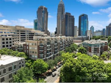 A vibrant city view featuring lush green trees lining the streets and modern architecture against a bright blue skyline at 400 N Church St # 226, Charlotte, NC 28202