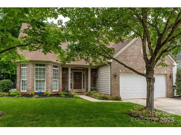 Charming brick home with a well-manicured lawn and inviting front entrance with a 'Welcome' sign at 5656 Cambridge Bay Dr, Charlotte, NC 28269