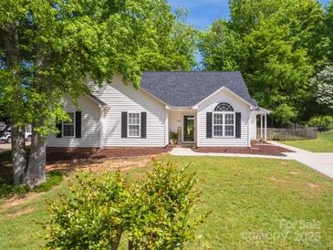 Charming home featuring a well-maintained lawn, manicured landscaping, and classic architectural details at 7122 Marlin St, Gastonia, NC 28056