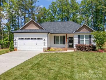 Charming single-story home featuring a two-car garage, manicured lawn, and delightful landscaping at 142 Highland Dr, New London, NC 28127