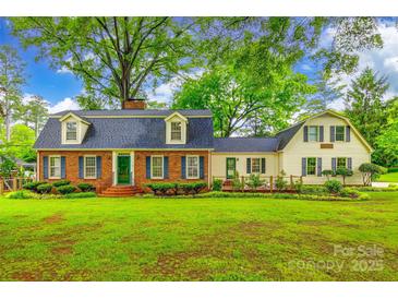 Charming two-story home with a brick facade, dormer windows, green door and shutters, and mature landscaping at 1581 Granville Rd, Rock Hill, SC 29732