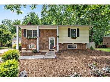 Charming two-story home with a mix of brick and siding, complemented by mature trees and flower boxes at 206 Pelham Ln, Fort Mill, SC 29715