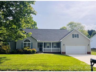 Charming single-story home featuring a covered porch, well-manicured lawn, and attached two-car garage at 318 Linsbury Ct, Gastonia, NC 28056