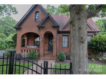 Charming brick home featuring an arched porch, black trim, and a well-maintained front yard with mature tree at 324 N 5Th St, Albemarle, NC 28001