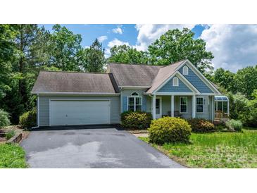 Charming home with blue and gray siding, a two-car garage, and mature landscaping, perfect for suburban living at 109 Gatwick Ct, Statesville, NC 28677