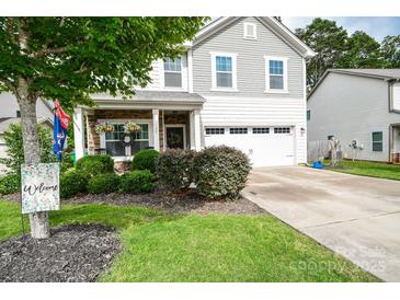 Charming two-story home with stone accents, a two-car garage, and landscaped front yard at 120 Tranquil Ct, Locust, NC 28097